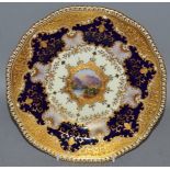 AN EARLY 20TH CENTURY COALPORT PLATE, lavishly decorated in raised gilt with a central landscape,