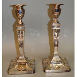 A GOOD PAIR OF ADAM DESIGN CLASSICAL CANDLESTICKS on square loaded bases 12ins high.