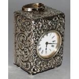 A SMALL VICTORIAN SILVER CASED CLOCK, 3ins high, the case repousse with flowers and scrolls,