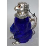 A DEEP BLUE GLASS MONKEY CLARET JUG with plated head, band and feet 7.75ins high.