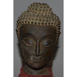 A VERY GOOD METAL BUDDHA’S HEAD, Possibly 15TH CENTURY, 5.5ins high, on a plinth.