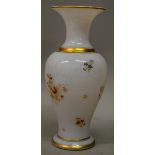 A VICTORIAN OPAQUE WHITE VASE painted with flowers 11ins high.