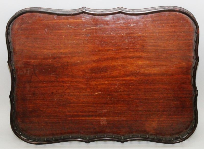 A GOOD CHIPPENDALE DESIGN MAHOGANY SERPENTINE SIDED TEA TRAY with spindle turned gallery 25ins