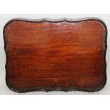 A GOOD CHIPPENDALE DESIGN MAHOGANY SERPENTINE SIDED TEA TRAY with spindle turned gallery 25ins