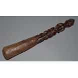 A CARVED WOOD TRIBAL CLUB, the handle as a female figure 14.5ins long.
