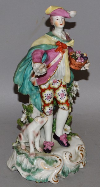 AN 18TH CENTURY DERBY FIGURE OF A GALLANT, standing with sweeping cape, beside a dog and flowering