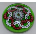 A GREEN GROUND BACCARAT PAPERWEIGHT, coloured canes on a green background. 3ins diameter.