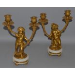A VERY GOOD PAIR OF LOUIS XVI DESIGN ORMOLU AND WHITE MARBLE CUPID CANDLESTICKS with two scrolling