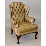 A GOOD GEORGIAN STYLE MAHOGANY LEATHER BUTTON BACK ARMCHAIR with curving arms, supported on carved