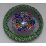 A BACCARAT MILLEFIORI CANE PAPERWEIGHT with multi-coloured central canes within a green border of