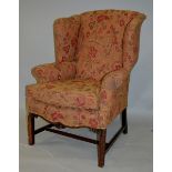 A GEORGE III DESIGN MAHOGANY FRAMED WING ARMCHAIR, shell carved frieze, moulded square legs united