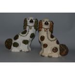 A PAIR OF STAFFORDSHIRE BROWN AND WHITE SEATED KING CHARLES SPANIELS 12.5ins high.