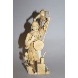 AN EARLY 20TH CENTURY JAPANESE CARVED IVORY FIGURE OF A MONKEY ENTERTAINER, the details engraved,