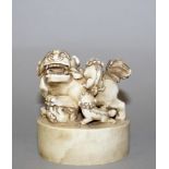 AN EARLY 20TH CENTURY CHINESE CARVED IVORY SEAL, the oval plinth surmounted by a buddhistic lion and