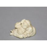 AN EARLY 20TH CENTURY JAPANESE CARVED IVORY NETSUKE OF DAIKOKU, unsigned, the deity reclining on his