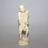 AN EARLY 20TH CENTURY SIGNED JAPANESE IVORY CARVING OF A FISHERMAN, holding a reed wrapped bundle of