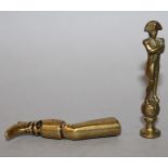 TWO SMALL BRASS SEALS, one designed as a leg wearing a boot with oval crested intaglio, the other as