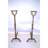 A PAIR OF WROUGHT IRON TORCHERE FIRE DOGS, each with a pair of adjustable hooks, on curving supports