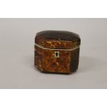 A SMALL REGENCY TORTOISESHELL TEA CADDY AND COVER with cut off corners, ivory frame and supported on