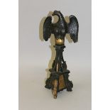 A CARVED AND GILDED WOODEN EAGLE ON STAND. 13.5ins high.