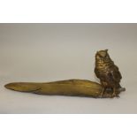 A BERGMANN BRONZE WISE OWL standing on a long feather, the owl as an inkstand 13ins long.