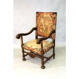 A 17TH CENTURY STYLE CARVED ARMCHAIR with tapestry back and seat.