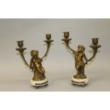 A GOOD PAIR OF 19TH CENTURY LOUIS XVI PATTERN CUPID BRONZE TWO LIGHT CANDLESTICKS on white