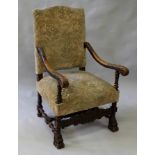 A 17TH CENTURY STYLE CARVED ARMCHAIR with padded back and seat.