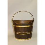 A DUTCH BRASS BOUND OVAL SHAPED BUCKET with liner and swing handle 12ins high.