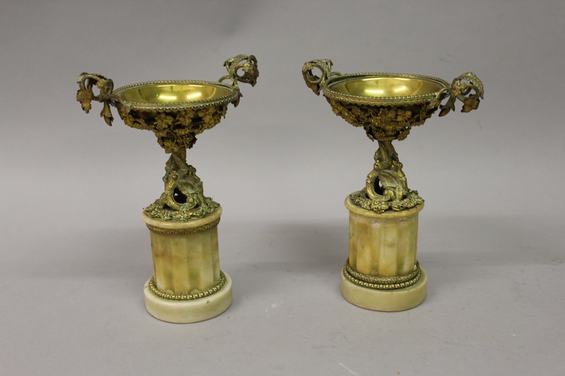 A GOOD PAIR OF LOUIS XVI DESIGN GILT METAL URNS with fruiting vines, supported on marble plinths