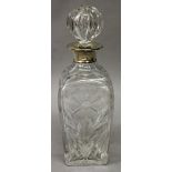 A SILVER TOP CUT GLASS DECANTER AND STOPPER.