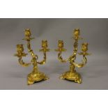 A GOOD PAIR OF LOUIS XVI ORMOLU THREE LIGHT CANDLESTICKS with acanthus decoration and circular bases