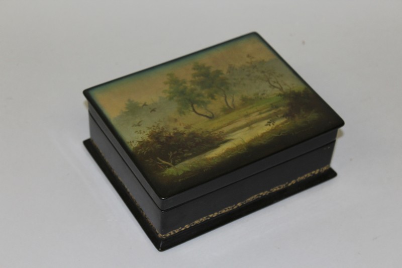 A RUSSIAN RECTANGULAR LACQUERED BOX AND COVER, the lid with a peaceful Lakeland scene 6.75ins wide.