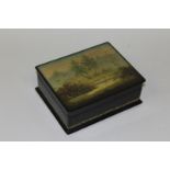 A RUSSIAN RECTANGULAR LACQUERED BOX AND COVER, the lid with a peaceful Lakeland scene 6.75ins wide.