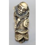 AN 18TH/19TH CENTURY JAPANESE CARVED IVORY NETSUKE OF A SENNIN, holding a drum and striker, 2.5in