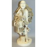 A LARGE FINE QUALITY SIGNED JAPANESE MEIJI PERIOD IVORY OKIMONO OF A BASKET & DRUM SELLER, the man