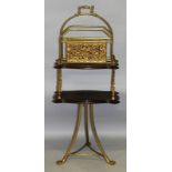 AN ORNATE CAST BRASS AND MAHOGANY REVOLVING MAGAZINE STAND. 3ft 4ins high.