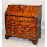 AN 18TH CENTURY WALNUT BUREAU with fall flap enclosing pigeonholes, small drawers and a well,
