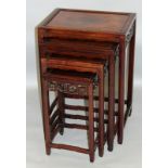 A NEST OF FOUR CHINESE ROSEWOOD RECTANGULAR TABLES with pierced and carved frieze. Largest 1ft