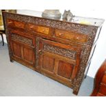 A 17TH CENTURY/18TH CENTURY OAK DRESSER, the rectangular plank top over a carved frieze and