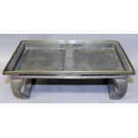 AN EARLY 20TH CENTURY CHINESE RECTANGULAR PEWTER STAND, supported on curved feet, the top surface