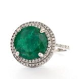 A 6.01 carat natural and untreated round cut Emerald, set in an 18 carat white gold ring and