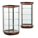 A pair of standing mahogany showcases 20th century, each with a glazed top over three curved beveled