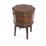 A George III brass-bound mahogany cellarette The octagonal hinged top opening to reveal a brass-