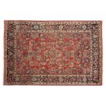 1193  A Sarouk Persian rug Circa 1940s, wool on cotton foundation, red field with trailing flowering