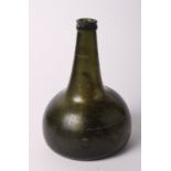 An 18th Century green blown glass onion-shaped wine bottle, 8" high