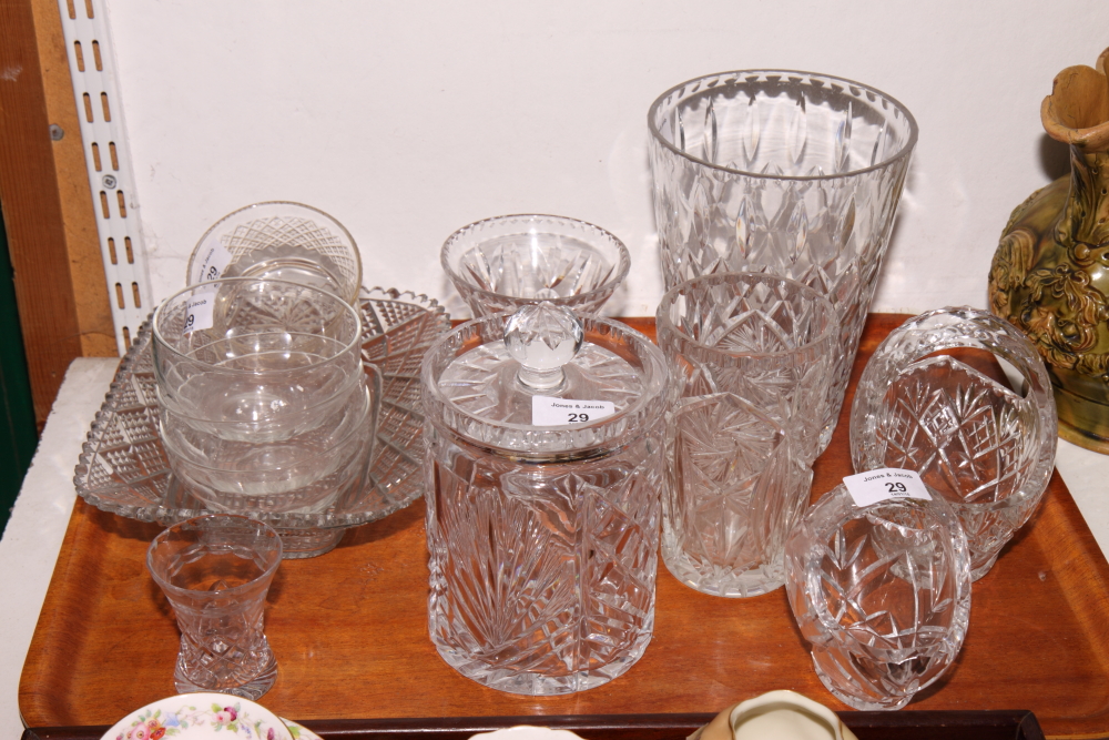 A cut glass biscuit jar and cover, two cut glass baskets, a cut glass waisted vase, a smaller