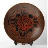 A Poole Pottery charger decorated in brown and red, 16" dia