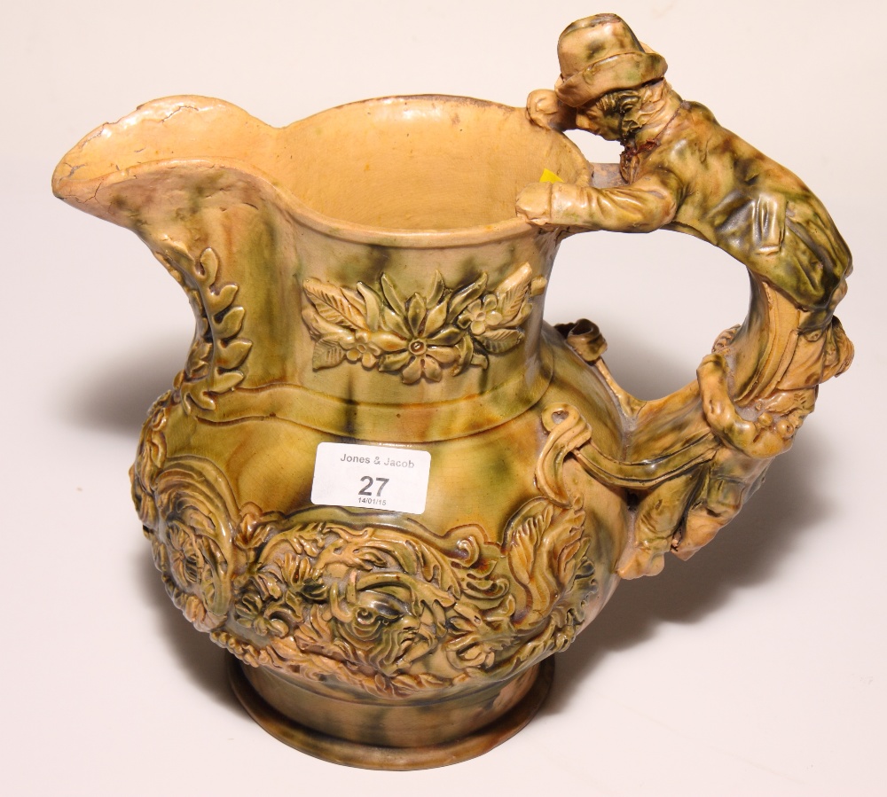 A 19th Century relief moulded jug with figure handle, 10" high