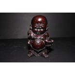 An oriental carved hardwood figure of a young Hotei, 6" high